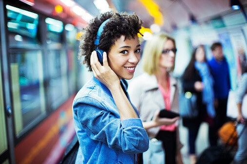 woman listening to music on headphones while commuting
