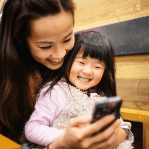 woman and daughter looking at phone